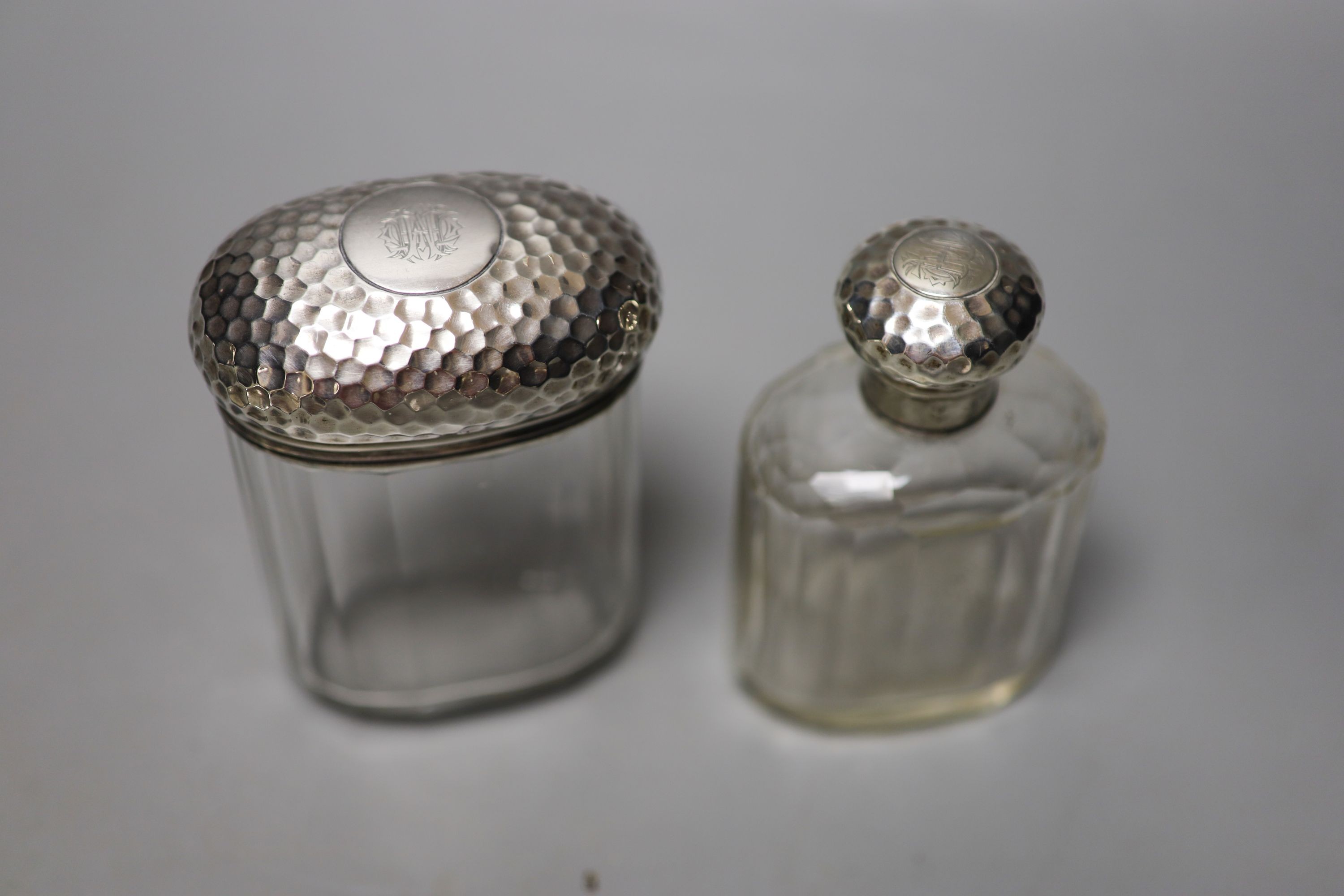 Six assorted silver mounted glass toilet jars, including a powder bowl and a Chinese white metal tot(a.f.).